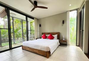 una camera da letto con un letto e un ventilatore a soffitto di Secret Garden at Bangtao Beach a Surin Beach