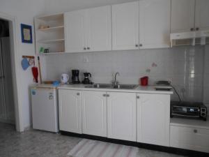 a kitchen with white cabinets and a sink at Meltemia Studio Samos near the beach in Kámpos