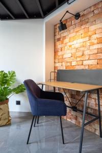 a meeting room with a wooden table and a blue chair at Studio LOFT12 in Kielce