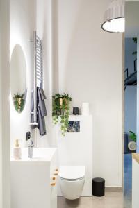 a white bathroom with a toilet and a sink at Studio LOFT12 in Kielce