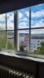 a window with a view of a city seen through it at El apartamento de arriba in Cedeira