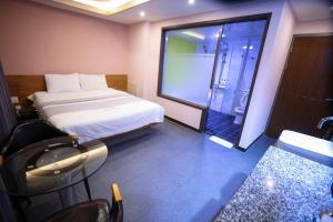 a bedroom with a bed and a glass shower at Seomyeon X in Busan