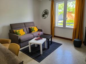 a living room with a couch and a table at Le gîte blinois in Blain +9 photos