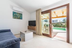 サン・テオドーロにあるAffittaSardegna- Villetta Meravigliaのソファとガラスの引き戸のあるリビングルーム +22枚の写真