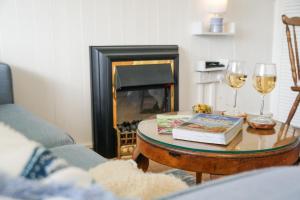 a living room with a table with a book and wine glasses at South Devon - River Dart Views - Free Parking - Pet Friendly in Galmpton-on-the-Dart