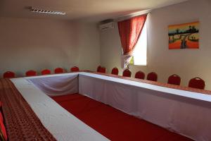 a conference room with red chairs and a long table at Hôtel Royal Malango in Fatick