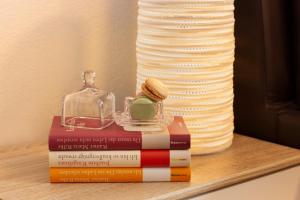 einem Stapel Bücher, die auf einem Regal mit einem Glasbehälter liegen in der Unterkunft Hotel & Boarding House Schlosserwirt in Mering