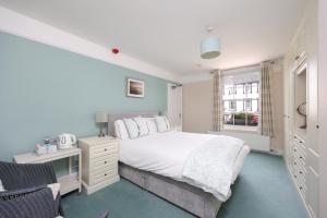 a bedroom with a bed and a desk and a window at Berwick House in Sidmouth