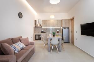 ein Wohnzimmer mit einer Couch und einem Tisch in der Unterkunft Katsaros Luxury Apts 5 min walk to beach in Planos
