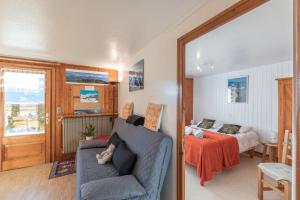 ein Wohnzimmer mit einer Couch und einem Bett in der Unterkunft Le Rouge-Gorge in Cordon