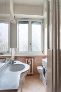 a bathroom with a sink and a toilet and windows at Youhosty - Val Passiria 4 in Milan +21 photos