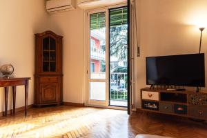 a living room with a tv and a sliding glass door at Youhosty - Val Passiria 4 in Milan