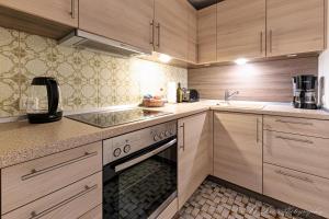 een keuken met houten kasten, een wastafel en een oven bij Fewo Isabella in Mittenwald