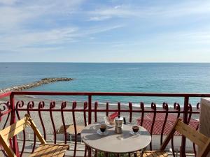 Una mesa en un balcón con vista al mar. en Finestra sul mare, en Ospedaletti