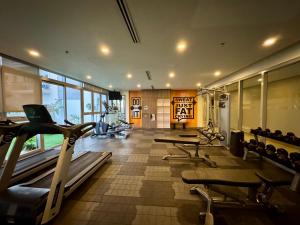 a gym with several treadmills and machines in a room at The Palladium - Executive Studio Pool-View in Iloilo City +14 photos