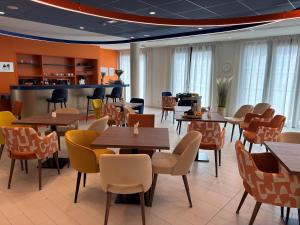 a restaurant with tables and chairs and a bar at DOMITYS - Le Tandem in Lens