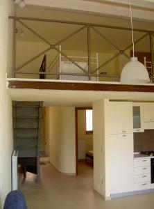 a loft bed in a room with a kitchen at Casa con panorama in Monticello