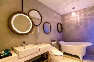 ein Badezimmer mit Waschbecken, WC und zwei Spiegeln in der Unterkunft Jin Pin Hotel in Magong