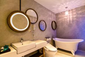 a bathroom with a sink toilet and two mirrors at Jin Pin Hotel in Magong