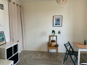 a living room with a table and a chair at Studio lumineux & calme à Biarritz - Parking privé gratuit in Biarritz