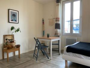 a bedroom with a bed and a table and a desk at Studio lumineux & calme à Biarritz - Parking privé gratuit in Biarritz
