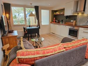 a living room with a couch and a kitchen with a table at Vakantiestudio Huize Hout GR01 in Grijpskerke
