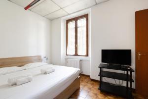 una camera da letto con due letti e una TV a schermo piatto di GuestHost - M3 Lodi Tibb-Brenta Comfy Flat a Milano