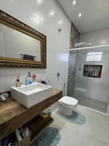 a bathroom with a sink and a toilet and a shower at Refúgio na Praia Casa Confortável e Acolhedora in São Francisco do Sul