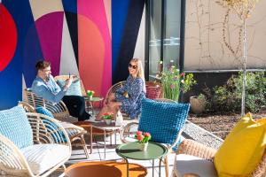 a group of people sitting in chairs on a patio at Three Corners Hotel Anna in Budapest +84 photos