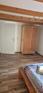 an empty room with a bed and wooden cabinets at Ferienhaus "Unter den Linden" in Eggesin