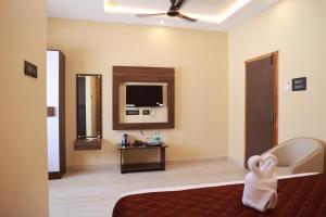une chambre d'hôtel avec un lit et une télévision dans l'établissement JPD Residency, à Dindigul