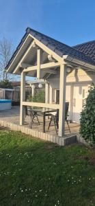 a pavilion with a picnic table in a yard at Ferienhaus "Unter den Linden" in Eggesin