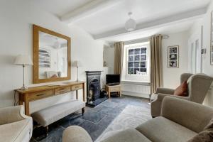 un soggiorno con camino e specchio di Pavement Cottage ad Ambleside