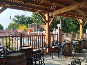 an outdoor patio with chairs and tables and a fence at Camping Domaine de Senaud in Albon