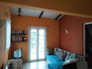 a living room with a blue couch and a sliding glass door at La perle de corail in Anse-Bertrand