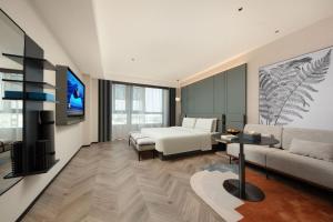 une chambre avec un lit et un salon dans l'établissement Atour S Hotel Xiamen Gaoqi Airport Huli District Government, à Xiamen