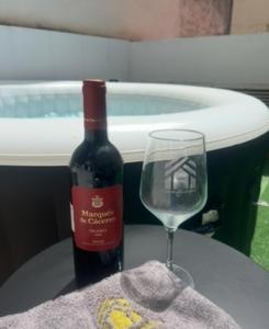 a bottle of wine and a wine glass on a table at Apartamentos de la Luz in Granada