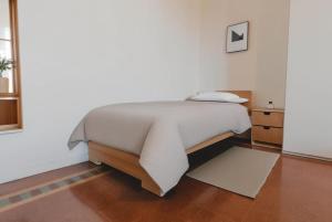 a bed in a white room with a bedskirtspectspectspectspects at [Duomo - City Center] Appartamento elegante con suite in Ravenna