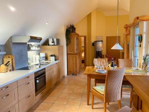 ツィングストにあるWellness-Residenz Wohnung 18のテーブルと椅子のあるキッチンとカウンターのあるキッチン +8枚の写真