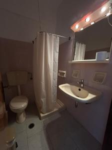 a bathroom with a sink and a toilet and a mirror at Smalis Studios in Lakkíon