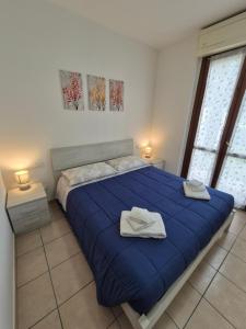 a bedroom with a blue bed with towels on it at Appartamento a 100m dal mare in Grottammare
