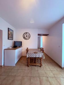a dining room with a table and a kitchen at Studio-Château Castelnaud-Au bord de la rivière in Castelnaud La Chapelle