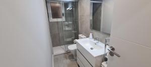 a bathroom with a sink and a toilet and a mirror at Samsara apartment, esencia de mar in El Vendrell +12 photos