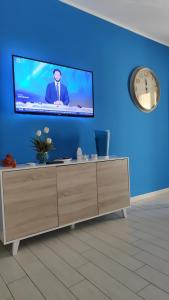 Una sala de estar con un televisor en una pared azul. en Appartamento Dolceluna, en San Vito lo Capo