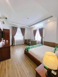a bedroom with a bed and a desk and a couch at Flora Quy Nhon Hotel in Quy Nhon +31 photos
