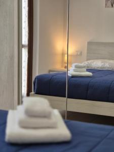 a mirror in a room with two beds and towels at Appartamento a 100m dal mare in Grottammare +6 photos