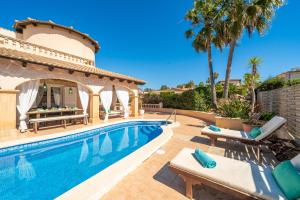 eine Villa mit Swimmingpool und Palmen in der Unterkunft Villa Son Serra, Pool and Chill Out close to the beach in Son Serra de Marina