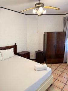 a bedroom with a bed and a ceiling fan at Rancho Rio Perlas in Cartago