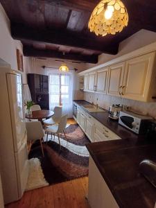a kitchen with white cabinets and a table and a dining room at Pension Nina in Český Krumlov +38 photos