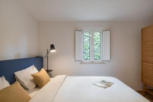 a bedroom with a bed with a window at Casa Moinho by Olala Homes in Santiago do Cacém